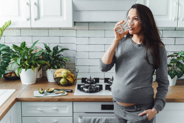 Pregnant woman drink glass of water